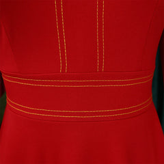 A close-up of a red dress featuring a high-waisted band with yellow contrast stitching.