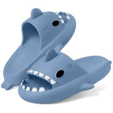 A pair of blue shark-shaped EVA slides with white teeth and black eyes.