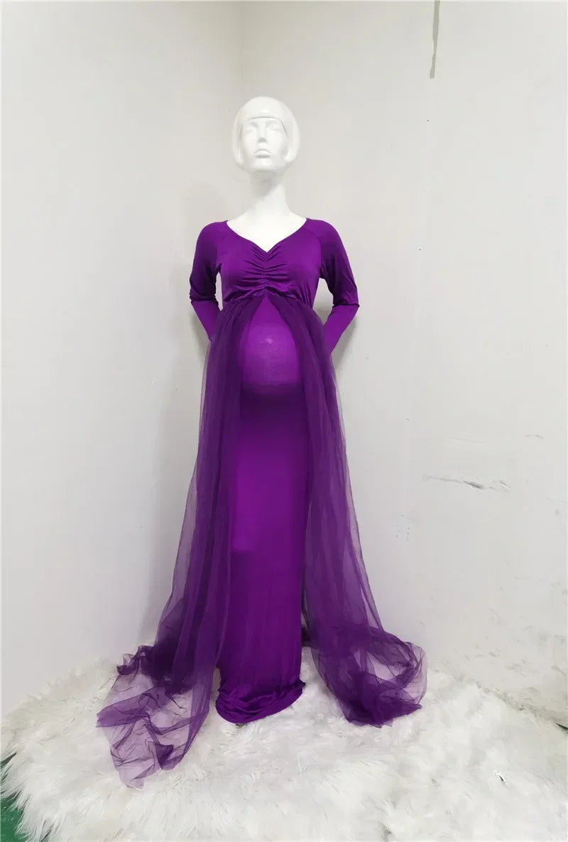 A long-sleeved purple maternity dress with a V-neck and a sheer tulle cape overlay.