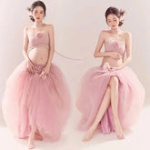 A pregnant woman wears a pink strapless tube top and a matching long mesh tutu skirt.