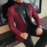 A man wears a red plaid blazer with black lapels over a black turtleneck sweater.