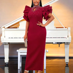 A woman wears a burgundy ankle-length sheath dress with ruffled sleeves and beaded neckline.