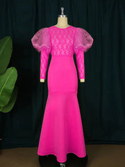 A hot pink floor-length mermaid evening gown featuring lace detailing and sheer puff sleeves.