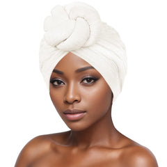 A woman wears a white, textured bubble cloth turban featuring a large decorative knot on top.