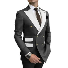 A man wears a charcoal grey double-breasted blazer with white lapels and matching pockets.