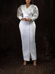 A white ankle-length sheath dress with a V-neck, beaded trim, and sheer lantern sleeves.