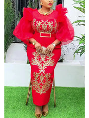 A woman wears a red long-sleeved evening gown featuring gold sequin embroidery and a belted waist.