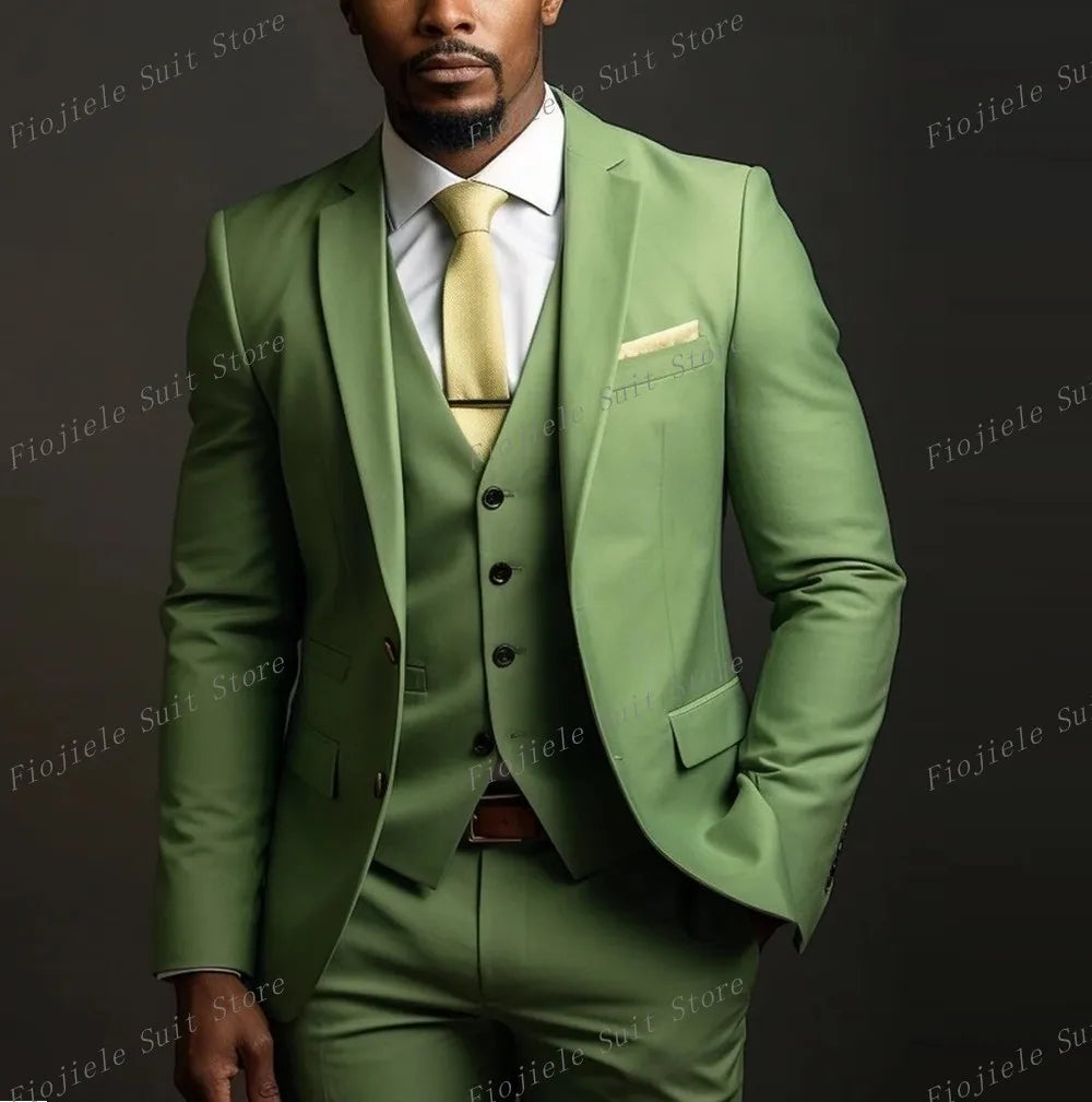 A man wears an army green three-piece suit with a white shirt and a gold tie.