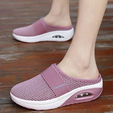 A pair of mauve mesh wedge slippers with a thick white sole and visible air cushioning.