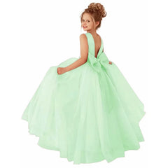 A young girl wears a sleeveless, floor-length mint green ball gown with a large bow on the back.