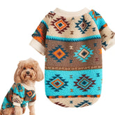 A small dog wearing a cozy, long-sleeved sweater with a colorful geometric totem print.