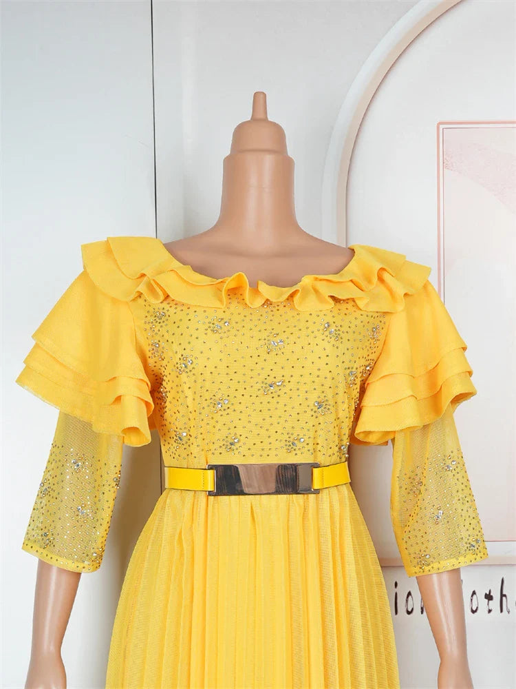 A yellow floor-length A-line dress with crystal embellishments, butterfly sleeves, and a belt.