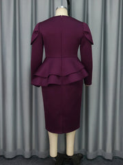 A back view of a dark purple long-sleeve midi dress with a double-layered peplum waist.