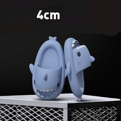A pair of light blue shark-shaped EVA slides standing upright on a white surface.