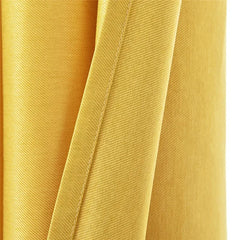 A close-up view of a solid yellow curtain panel featuring a woven texture and a stitched hem.