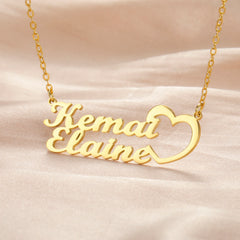 A gold-toned personalized nameplate necklace featuring the names Kemal and Elaine with a heart icon.