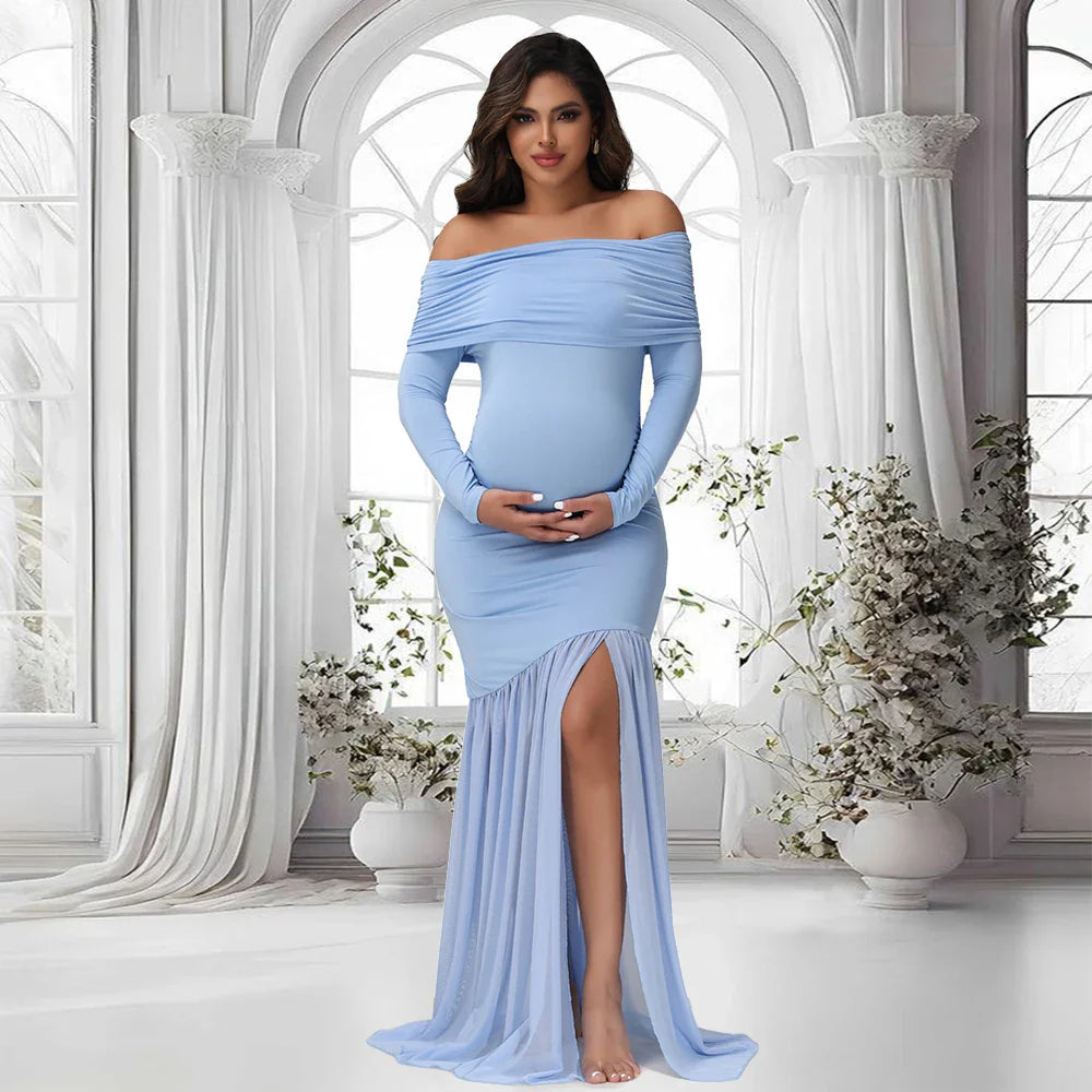 A pregnant woman wears a light blue off-shoulder maternity gown with long sleeves and a side slit.