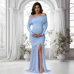 A pregnant woman wears a light blue off-shoulder maternity gown with long sleeves and a side slit.