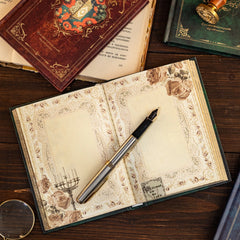 An open vintage-style notebook with floral borders and a fountain pen rests on a wooden table.