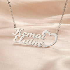 A silver personalized double nameplate necklace featuring the names Kemar and Elaine with a heart.