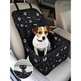A black dog car booster seat with a white paw and bone print installed on a car seat.