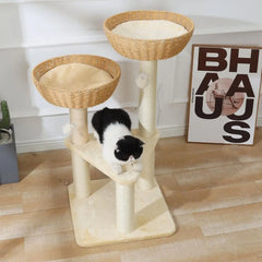 A cat tree with two handwoven rattan baskets and a plush platform, featuring a black and white cat.