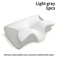 A light gray ergonomic memory foam pillow with a contoured shape for neck and head support.