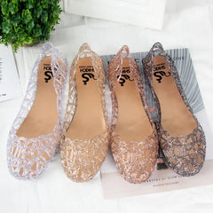 Four pairs of glittery, hollow-patterned PVC jelly sandals in silver, gold, rose gold, and grey.