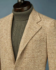 A tan tweed blazer worn over a dark olive green cable-knit turtleneck sweater.