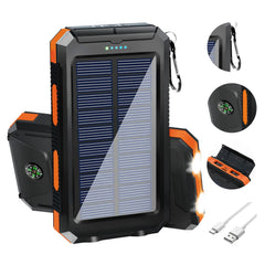 A black and orange portable solar power bank with a built-in compass, flashlight, and USB cable.