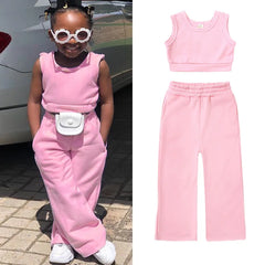 A two-piece pink cotton set for girls featuring a sleeveless crop top and matching wide-leg pants.