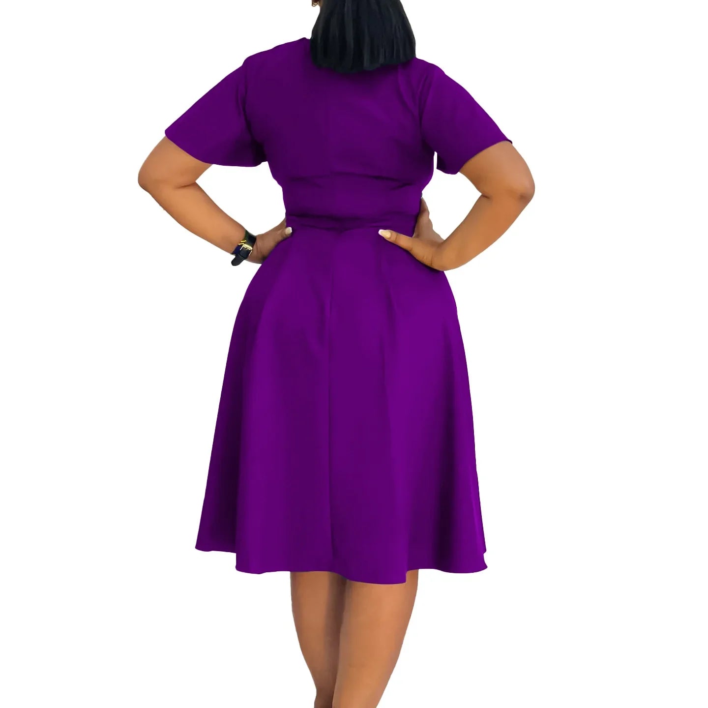 A woman wears a solid purple short-sleeved knee-length A-line swing dress from the back view.
