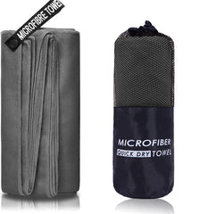 A grey microfiber sports towel shown unfolded next to its compact mesh carrying bag.