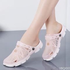 A pair of light pink jelly sandals with cut-out details and a back strap worn on feet.