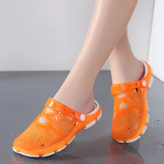 A pair of orange translucent jelly sandals with a white sole and adjustable back strap.