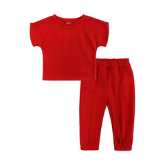 A solid red two-piece set for girls featuring a short-sleeve t-shirt and matching elastic pants.
