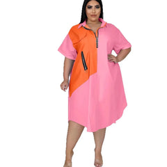A plus-size woman wears a loose, short-sleeve color-blocked dress with a front zipper.