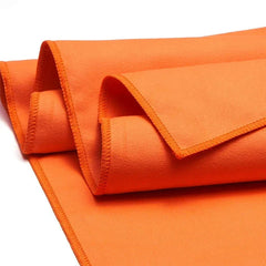 A bright orange microfiber sports towel with stitched edges folded on a white background.