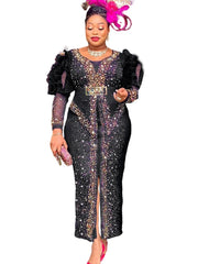 A woman wears a black, ankle-length sheath dress with puff sleeves and diamond embellishments.