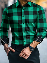A man wears a green and black checkered long-sleeved button-down shirt with polka-dot cuffs.