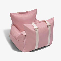 A pink waterproof pet car seat bed with white carrying straps and a removable cover.