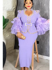 A woman wears a lavender long-sleeved dress with ruffled sleeves, gold embellishments, and a belt.