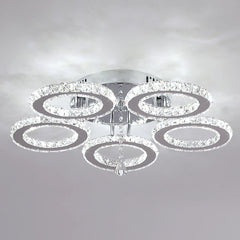 A modern flush-mount ceiling light featuring five interlocking crystal-encrusted chrome rings.