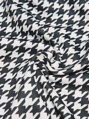 A close-up view of fabric featuring a classic black and white houndstooth pattern.