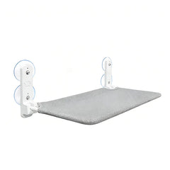 A grey fabric cat window perch with white support brackets and suction cups.