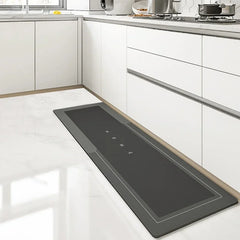 A long, rectangular, dark grey kitchen floor mat with the word HOME printed in the center.