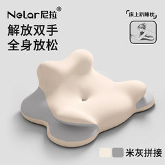 A beige and grey memory foam pillow with an irregular, ergonomic shape designed for prone positioning.