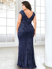 A plus-size woman wears a floor-length navy blue mermaid evening gown with sequin embellishments.