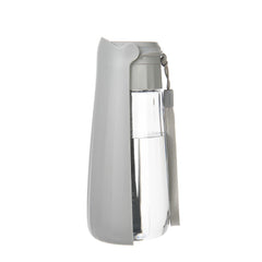 A grey portable pet water bottle with a clear reservoir and an attached carrying strap.