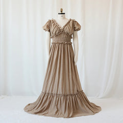 A tan bohemian maternity maxi dress with a V-neck, ruffled trim, and short puff sleeves.